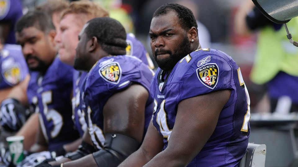 Oher sits on the beach during an NFL game between the Baltimore Ravens and the Buffalo Bills in 2010. - Nick Wass/AP