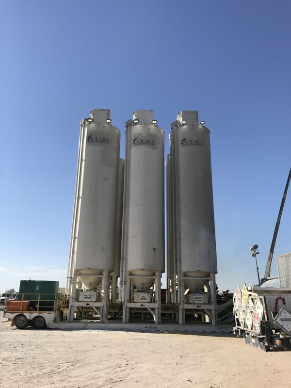 FILE PHOTO: Tanks holding sand that will be used to hydraulically fracture, or frack, an Exxon Mobil Corp oil well are seen near Midland