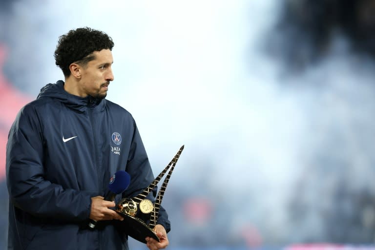 El defensor brasileño del París SG Marquinhos sujeta su trofeo en la ceremonia de celebración de su récord de 435 partidos con el PSG, después del partido de la Ligue 1 PSG-Lyon, en el Parque de los Príncipes de París, el 21 de abril de 2024 (FRANCK FIFE)