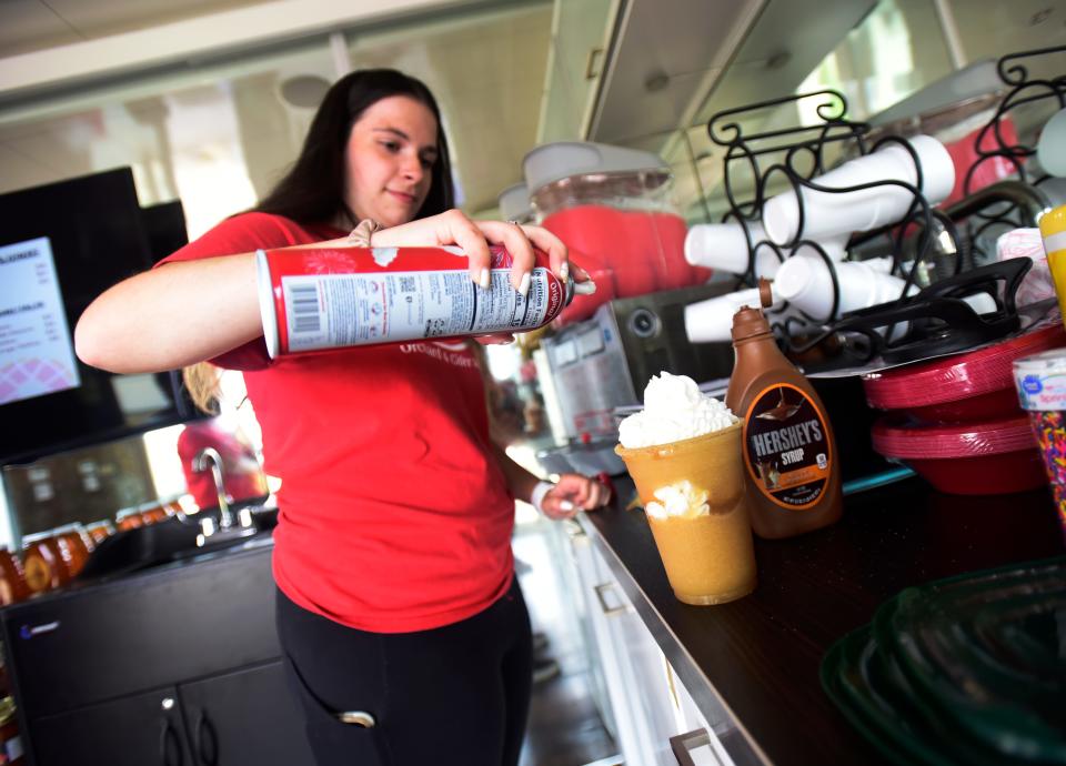 McCallum’s Orchard and Cider Mill employee Karissa Fay makes a deluxe cider slushy at the pod at the Lot venue at Fourth and Water streets in downtown Port Huron on Friday, July 8, 2022.