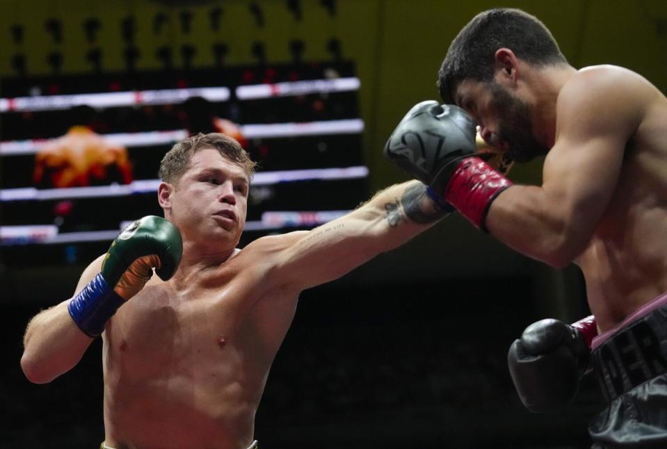 Canelo Álvarez, left, jabs John Ryder in the head during their super middleweight title fight on May 6.