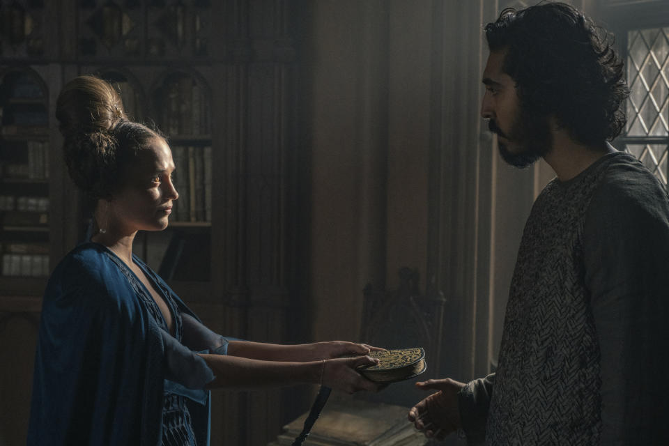 This image released by A24 shows Alicia Vikander, left, and Dev Patel in a scene from "The Green Knight." (Eric Zachanowich/A24 Films via AP)