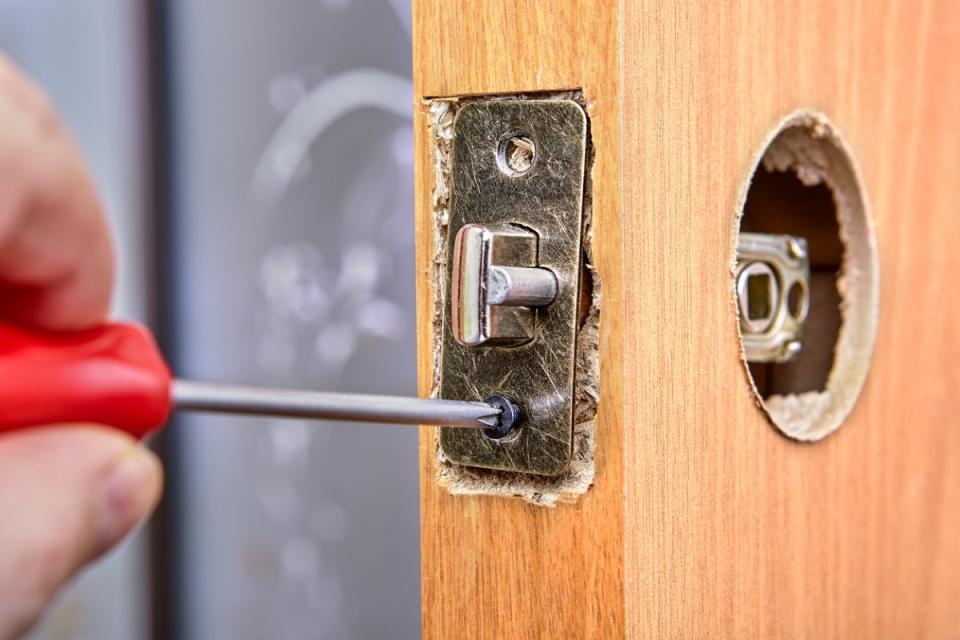 Screwdriver used to unscrew latch plate on a door.