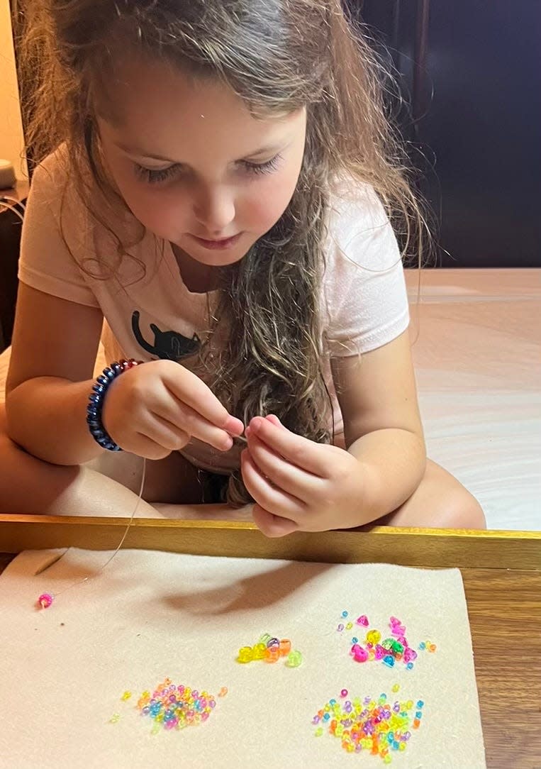 A young artist making beaded friendship bracelets