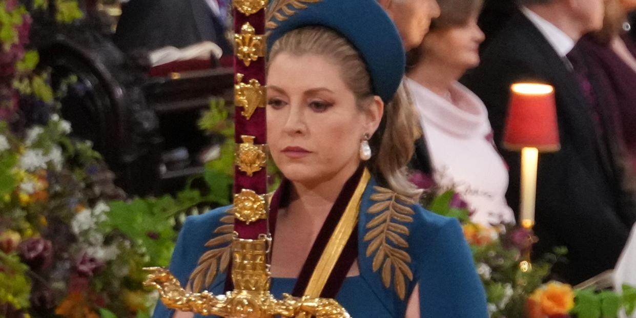 lord president of the council, penny mordaunt, carries the gold sword of state, in the procession, she looks like she is concentrating hard and the sword looks very heavy