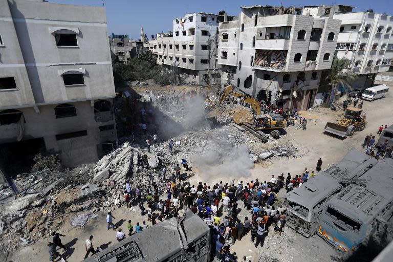 A digger removes debris on August 20, 2014 from a building in Gaza City's Sheikh Radwan neighbourhood destroyed the night before in an Israeli air strike which killed the wife and infant daughter of elusive Hamas military chief Mohammed Deif