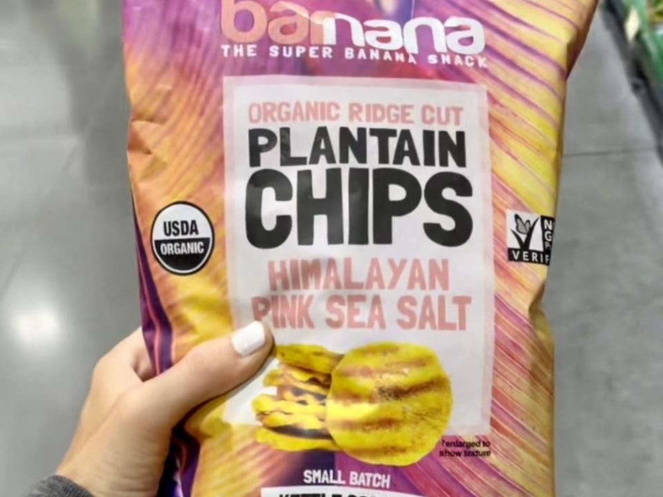 hand holding a bag of barnana plantain chips from costco