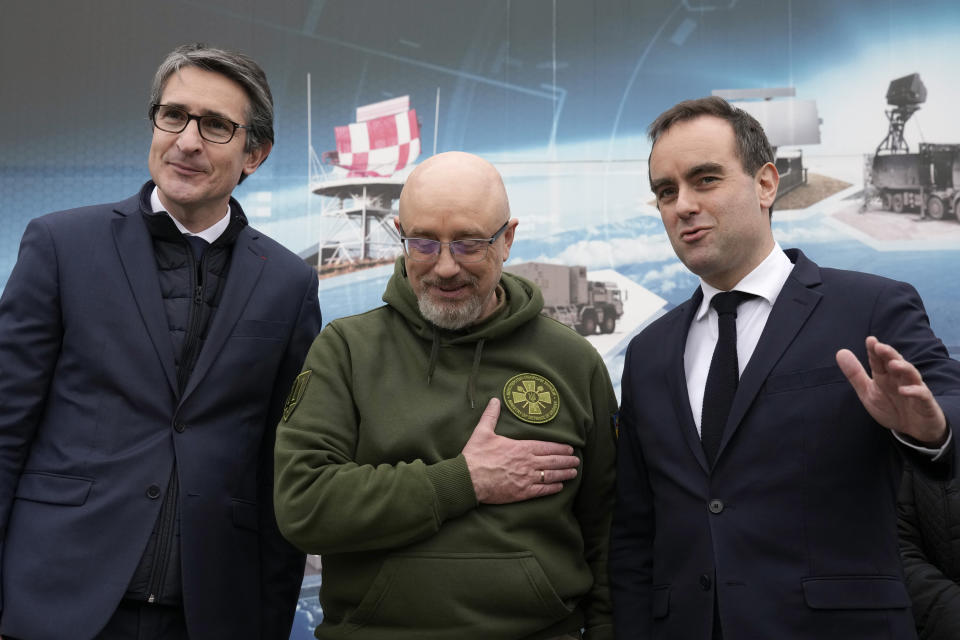 French Defense Minister Sebastien Lecornu, right, and Ukrainian Minister of Defense Oleksii Reznikov, center, pose with Chairman and CEO of Thales Group Patrice Caine, during a visit at Thales radar factory in Limours, south west of Paris, France, Wednesday, Feb. 1, 2023. France has guaranteed Kyiv the delivery of a Ground Master 200 (GM200) radar, produced by the French manufacturer Thales. This medium-range radar is capable of spotting enemy aircraft at 250 km and engaging them at 100 km, whether they are flying at low speed and low altitude like drones or at high altitude like fighter planes. (AP Photo/Christophe Ena)