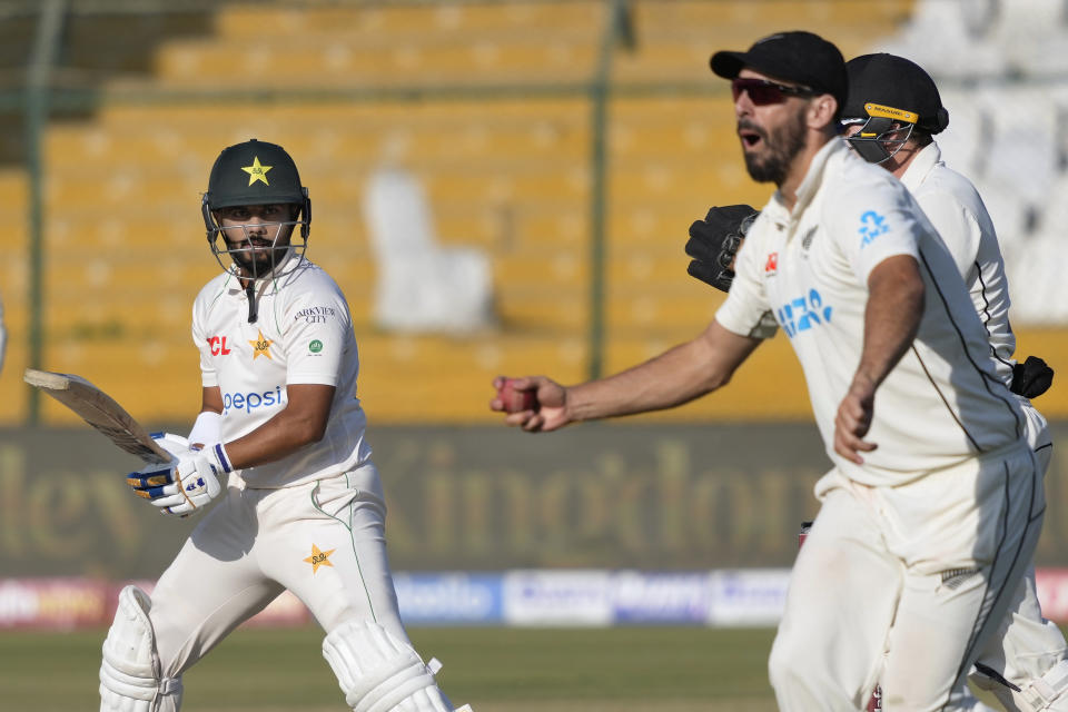 Pakistan's Saud Shakeel, left, reacts after New Zealand's Daryl Mitchell, right, takes his catch to dismiss him during the fifth day of the second test cricket match between Pakistan and New Zealand, in Karachi, Pakistan, Friday, Jan. 6, 2023. (AP Photo/Fareed Khan)