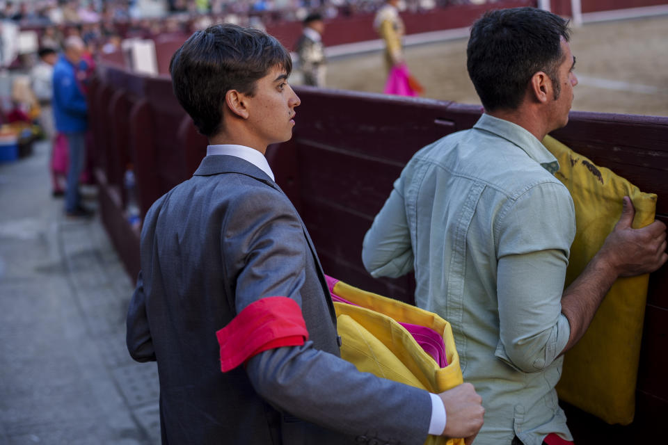 Matador's assistant Adrian Navas Barrientos, 21, left, brother of the Ecuadorian bullfighter Mario Navas watches a bullfight with small bulls at Las Ventas bullring in Madrid, Spain, Sunday, March 26, 2023. Those aged over 75 were the least likely to attend. While bullfighting is nowhere close to drawing the crowds of half a century ago, it remains an important, if divisive, symbol of Spanish identity in the country's south and central regions. (AP Photo/Manu Fernandez)