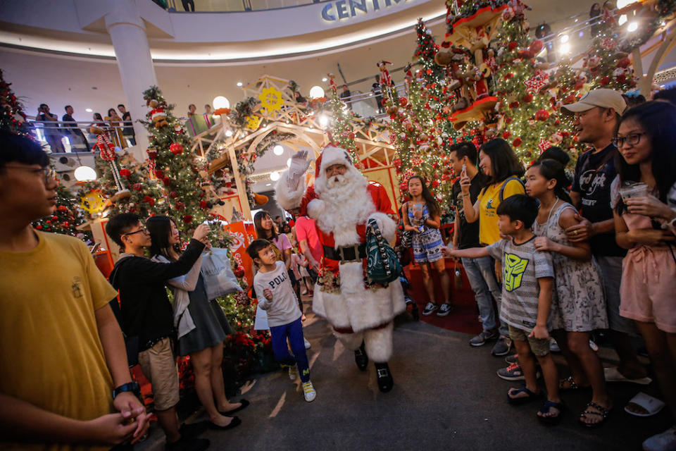 Santa Claus entertaining the crowd at the centre court of Mid Valley Megamall. — Picture by Hari Anggara.