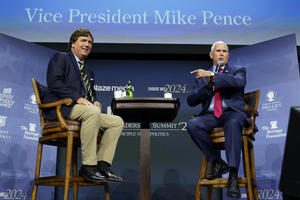 Republican presidential candidate former Vice President Mike Pence talks with moderator Tucker Carlson, left, during the Family Leadership Summit, Friday, July 14, 2023, in Des Moines, Iowa. (AP Photo/Charlie Neibergall)