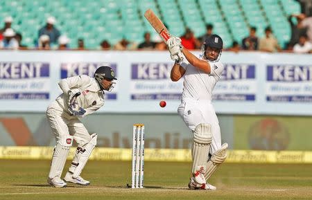 Cricket - India v England - First Test cricket match - Saurashtra Cricket Association Stadium, Rajkot, India - 12/11/16. England's captain Alastair Cook plays a shot as India's wicketkeeper Wriddhiman Saha (L) looks on. . REUTERS/Amit Dave