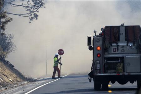 Dust from a tree felled by firefighters rises over Highway 120 at the Rim Fire just outside of Yosemite National Park, California, August 28, 2013. REUTERS/David McNew