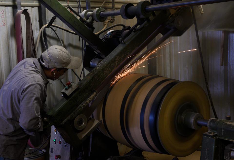 An employee smoothes a newly charred barrel for bourbon use at Kelvin Cooperage in Louisville, Kentucky on April 12, 2019. - To be called bourbon in the United States the whiskey mash contents require a minimum of 51 percent corn and stored in a new barrel lined with charred oak. After Canada, China, Mexico and the European Union slapped import duties from 10 to 25 percent on US whiskey and bourbon in 2018, exports dropped over 12 percent in the second quarter. Whiskey can be aged in used barrels and many of the barrels are sent overseas. (Photo by Andrew CABALLERO-REYNOLDS / AFP)        (Photo credit should read ANDREW CABALLERO-REYNOLDS/AFP/Getty Images)