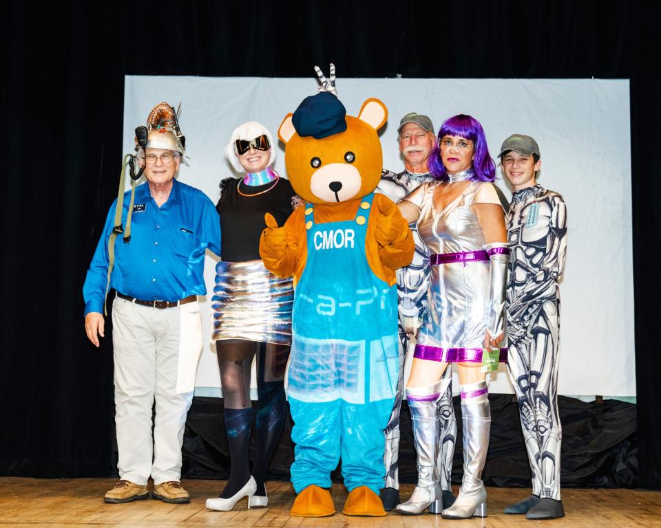 Contestants in the costume contest join the Children's Museum of Oak Ridge mascot Charlie Bear on stage. Guests were invited to dress in futuristic attire to celebrate the theme, “Party Like It’s 2073!”