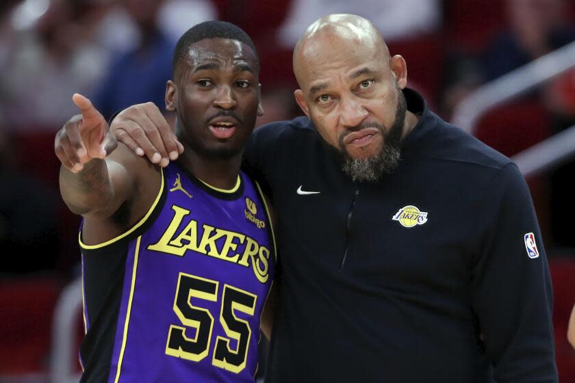 Los Angeles Lakers guard D'Moi Hodge (55) talks with head coach Darvin Ham during a free throw against the Houston Rockets during the second half of an NBA basketball game Wednesday, Nov. 8, 2023, in Houston. (AP Photo/Michael Wyke)