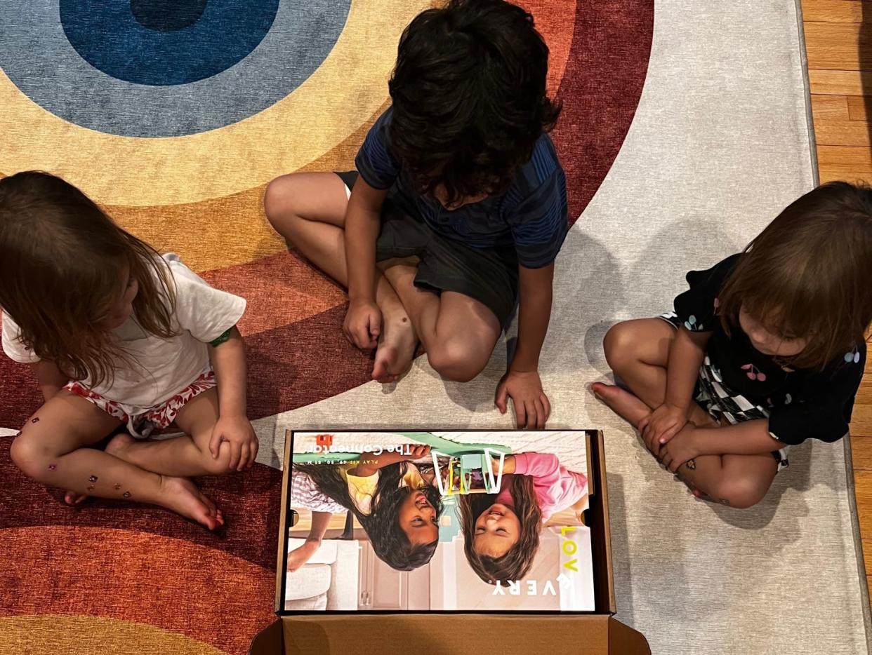 Kids sitting in front of a box full of toys