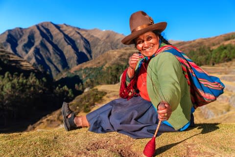 A Peruvian woman spinning wool by hand in the Sacred Valley - Credit: Getty