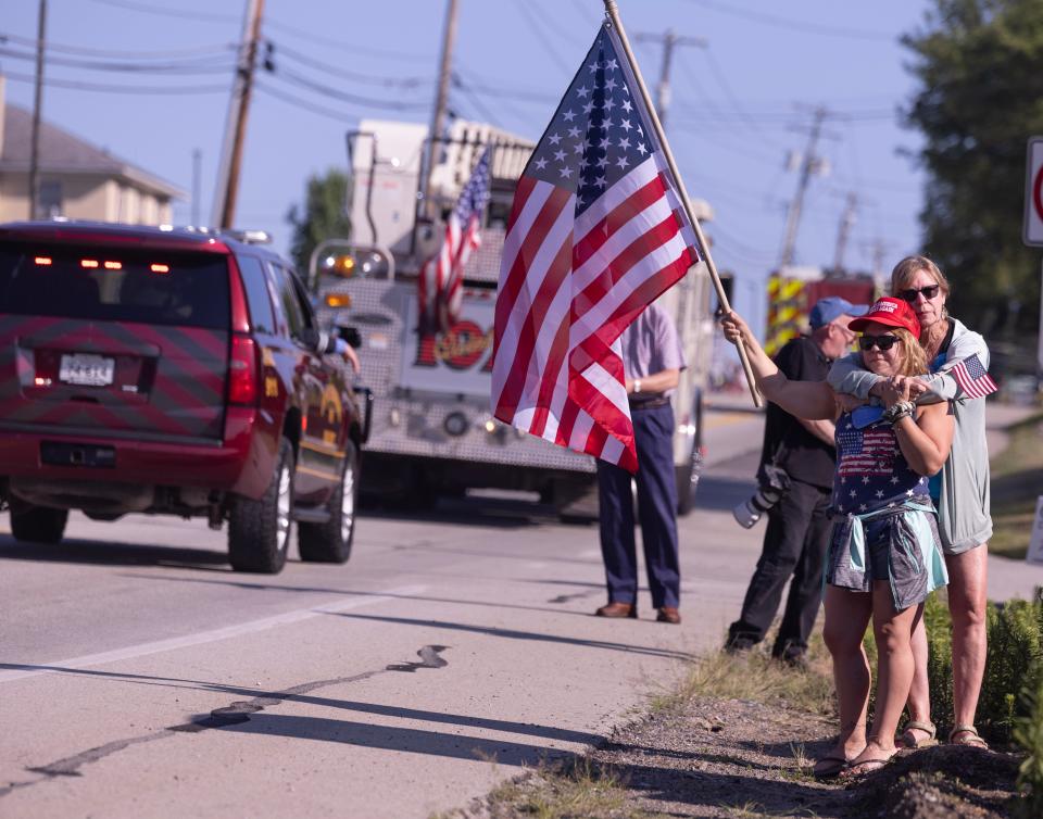 Merri Carbo,left, is consoled by friend Jane Wesoloski outside Freeport Senior High in Freeport Pennsylvania as a motorcade of fire engines and EMS vehicles headed off to the funeral of Corey Comperatore the Buffalo Township man killed at SaturdayÕs rally for former President Donald Trump from a would-be assassinÕs stray bullet. Kevin Whitlock / Massillon Independent