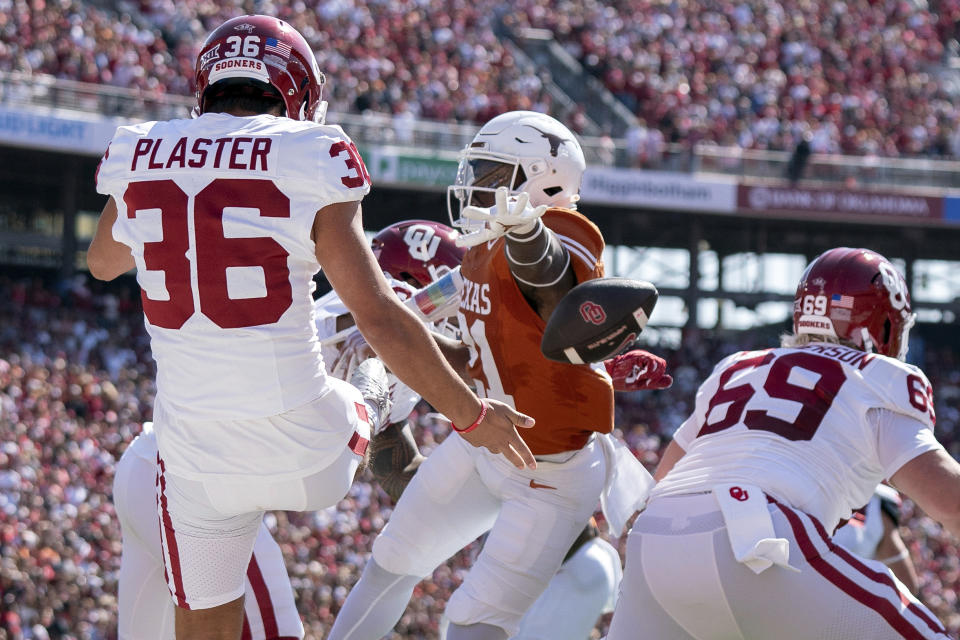 Texas defensive back Kitan Crawford (21) blocks a punt by Oklahoma punter Josh Plaster (36) during the first half of an NCAA college football game at the Cotton Bowl, Saturday, Oct. 7, 2023, in Dallas. The ball was recovered in the end zone by Texas' Malik Muhammad for a touchdown. (AP Photo/Jeffrey McWhorter)