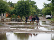 Children play on a street in the aftermath of Hurricane Orlene in Isla del Bosque, Mexico, Monday, Oct. 3, 2022. Hurricane Orlene made landfall on Mexico's Pacific coast near the tourist town of Mazatlan on Monday before quickly weakening over western Mexico. (AP Photo/Fernando Llano)