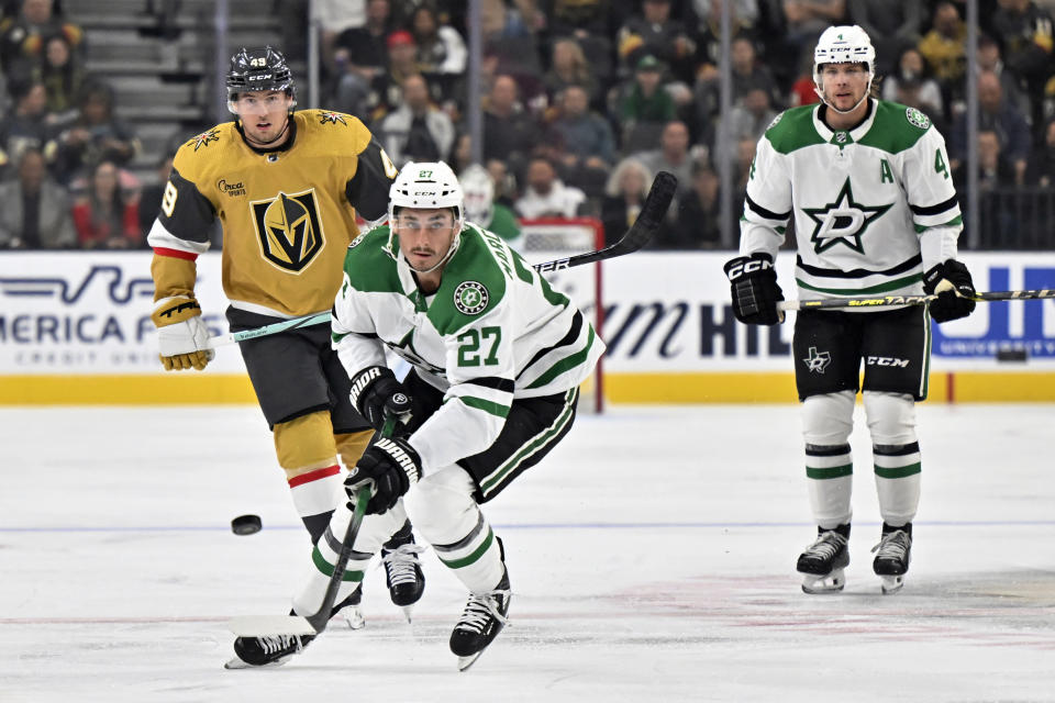 Dallas Stars left wing Mason Marchment (27) skates with the puck against Vegas Golden Knights center Ivan Barbashev (49) during the first period of an NHL hockey game Tuesday, Oct. 17, 2023, in Las Vegas. (AP Photo/David Becker)