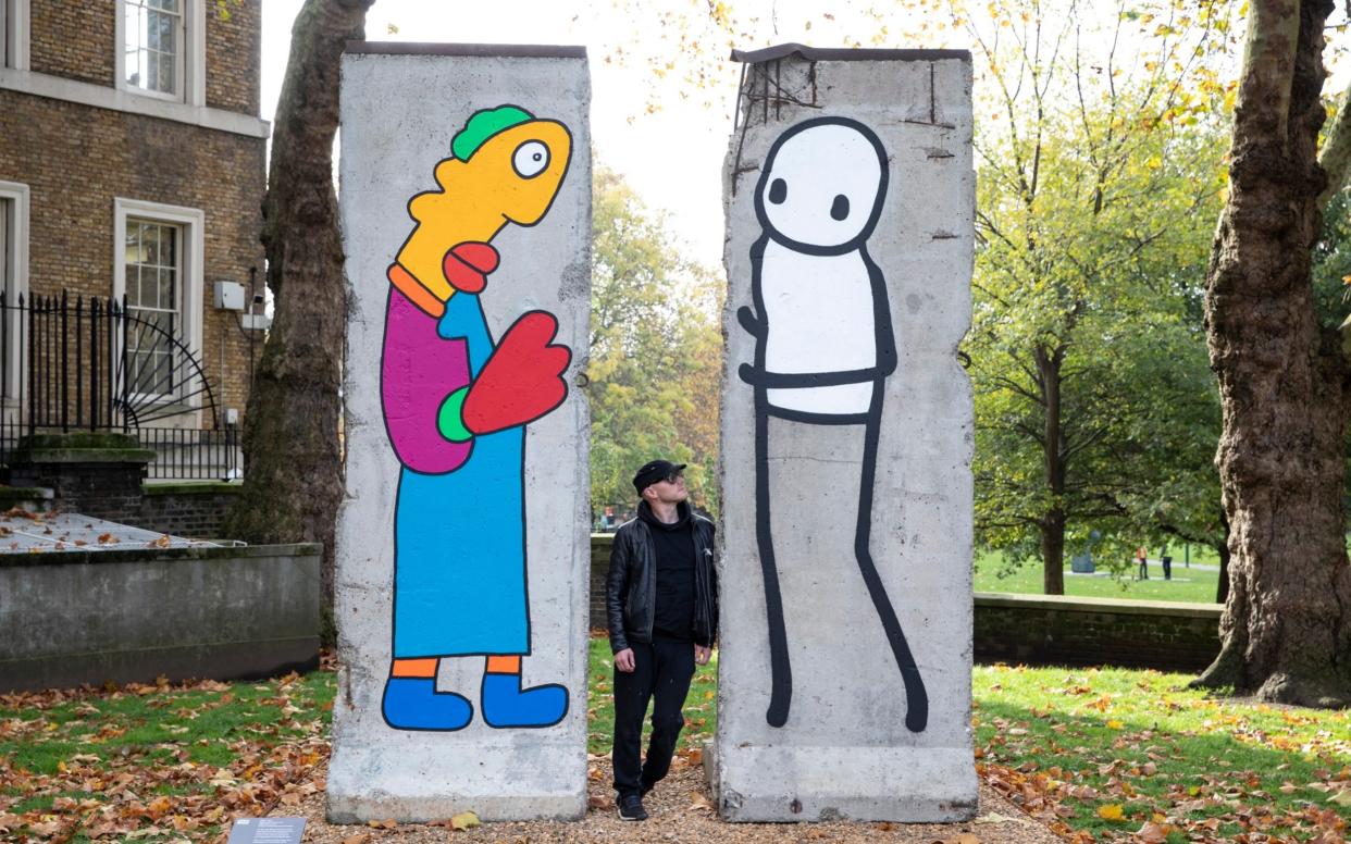 Stik with his installation which marks the 30th anniversary of the fall of the Berlin Wall - Heathcliff O'Malley 