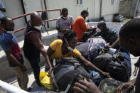 Haitian migrants deported from the US pick up their luggage at the Toussaint Louverture International Airport in Port-au-Prince, Haiti, Sunday, Sept. 19, 2021. Thousands of Haitian migrants have been arriving to Del Rio, Texas, to ask for asylum in the U.S., as authorities begin to deported them to back to Haiti which is in a worse shape than when they left. (AP Photo/Rodrigo Abd)