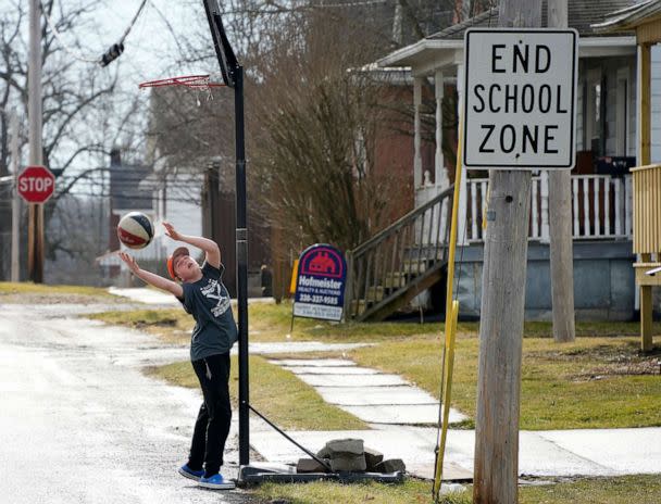 PHOTO: A boy reaches for a rebound as he shoots baskets in East Palestine, Pa, Feb. 9, 2023, as residents were allowed back in their homes after a derailment of a Norfolk Southern freight train forced their evacuation. (Gene J. Puskar/AP)