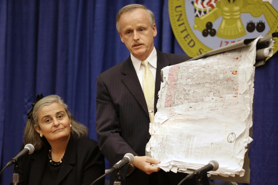 Kathryn Condon, executive director, Army National Military Cemeteries, left, listens as Patrick Hallihan, Superintendent of Arlington National Cemetery, holds up old map as an example of what had been used by the cemetery, during a news conference in Washington, Monday, Oct. 22, 2012 to present the ANC Explorer application for the cemetery. Arlington National Cemetery plans to make available to the public the detailed geospatial database it has developed over several years while overhauling its records and responding to reports of misidentified remains. The database will be available over the Internet and through a mobile phone app that visitors to the cemetery can take with them to find a specific gave anywhere in the cemetery. (AP Photo/Jacquelyn Martin)