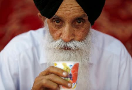 An Afghan Sikh man drinks from a cup inside a Gurudwara, or a Sikh temple, during a religious ceremony in Kabul, Afghanistan June 8, 2016. REUTERS/Mohammad Ismail