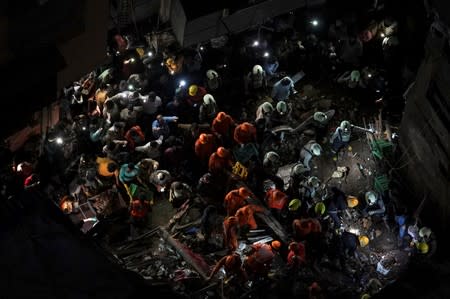 Rescue workers search for survivors at the site of a collapsed building in Mumbai