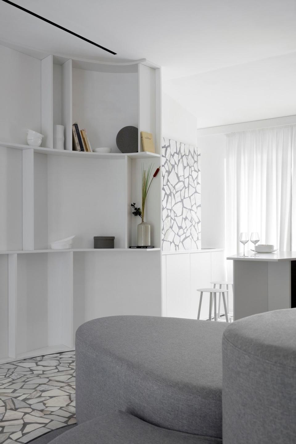 The organic shapes of the sofa mimic the curves of the open shelving.