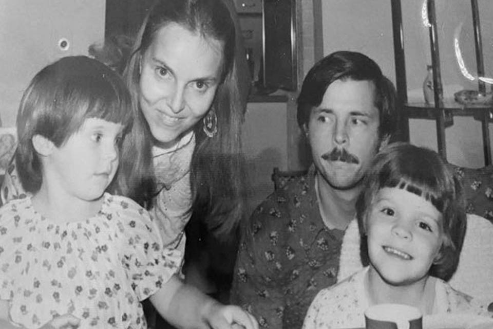 Black-and-white family photo with a mother, a father, and two young children.