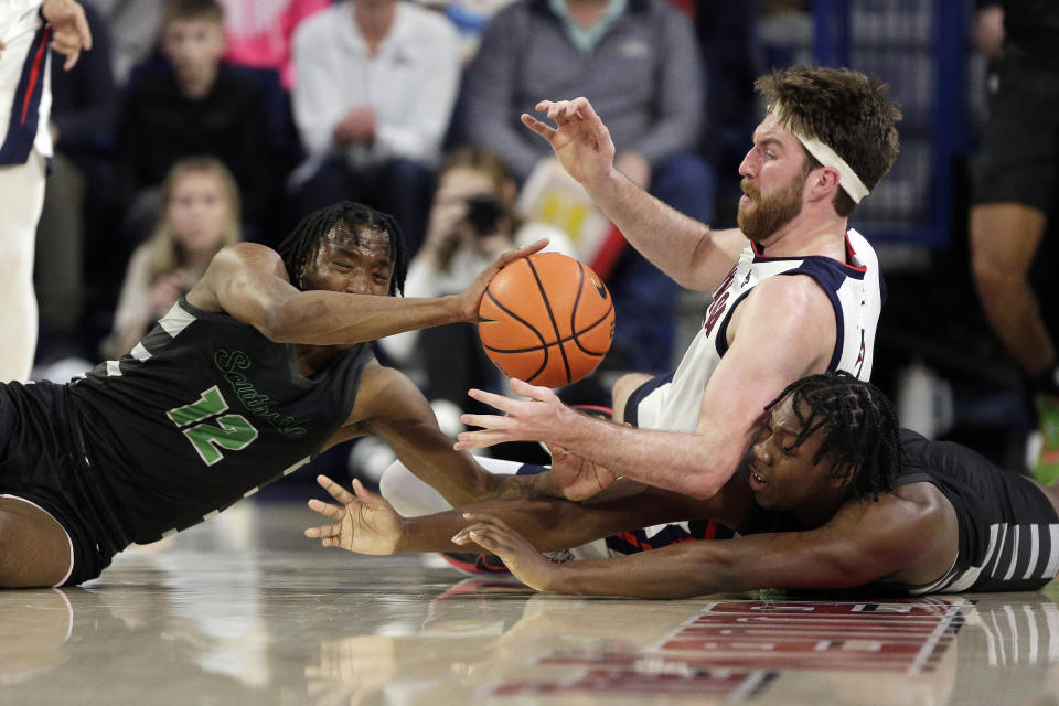 Chicago State guard Brent Davis, left, and forward Tehshaundre Cole, right, go after the ball against Gonzaga forward Drew Timme during the first half of an NCAA college basketball game, Wednesday, March 1, 2023, in Spokane, Wash. (AP Photo/Young Kwak)