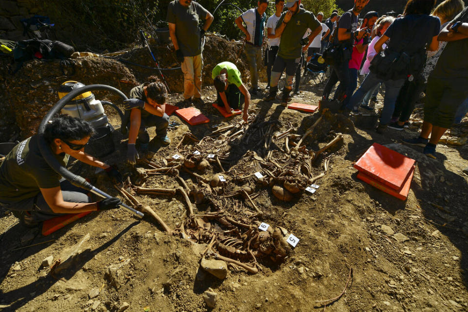 Archeologists inspect a grave site in Ollacarizqueta, Spain, containing what they believe to be the remains of sixteen republican prisoners killed during the Spanish Civil War - Credit: AP