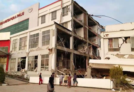 People stand outside of damage hospital after an earthquake hit in Palu, Indonesia Sulawesi Island, September 29, 2018. Antara Foto/BNPN via REUTERS