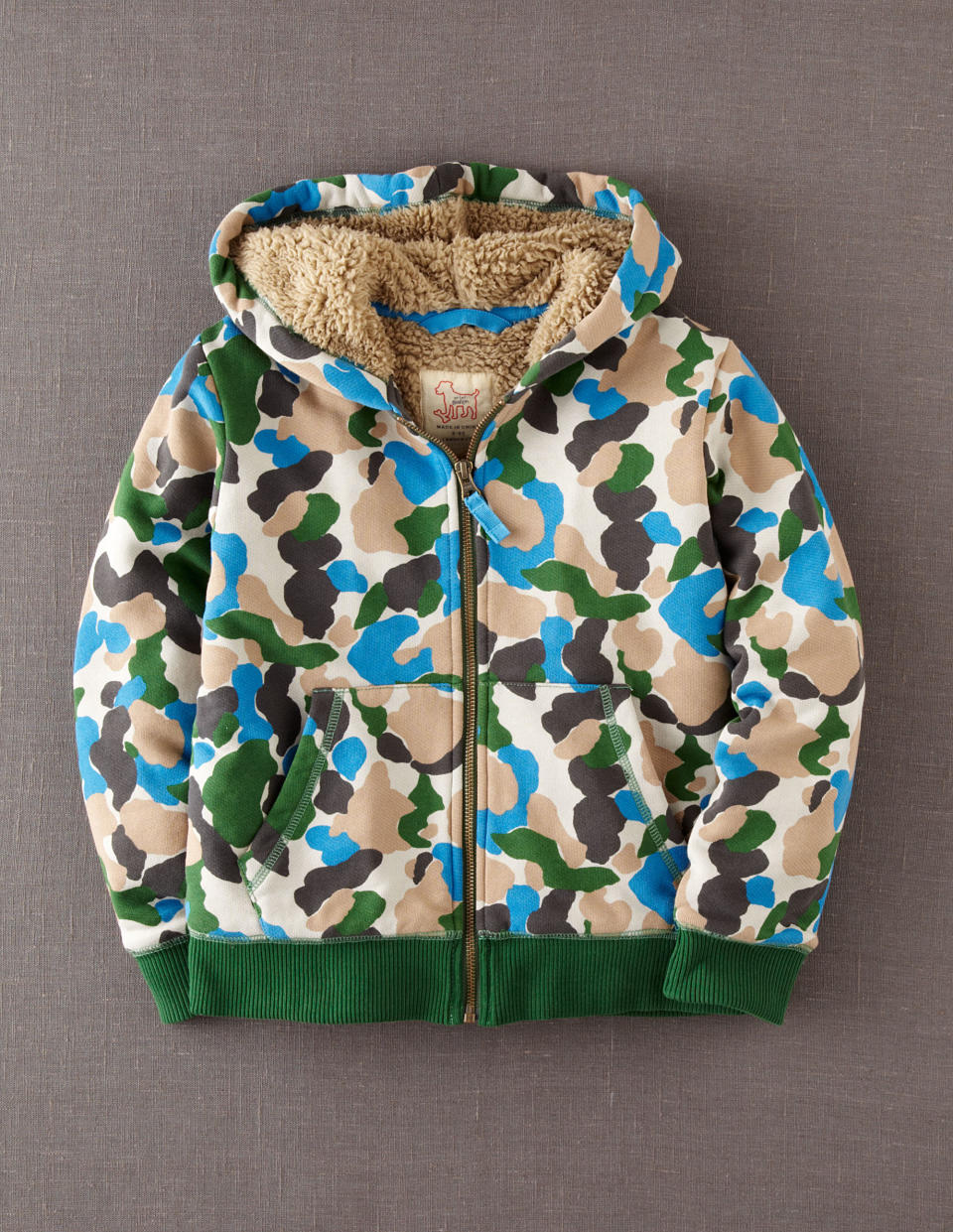 This product image released by Mini Boden shows a children's shaggy camouflage hoodie. The print that at one time was only a tool for military troops to go unnoticed has become a front-and-center look in fashion. It’s been adapted in luxe fur, sequin sweaters, athletic wear and casual kicks. (AP Photo/Mini Boden)