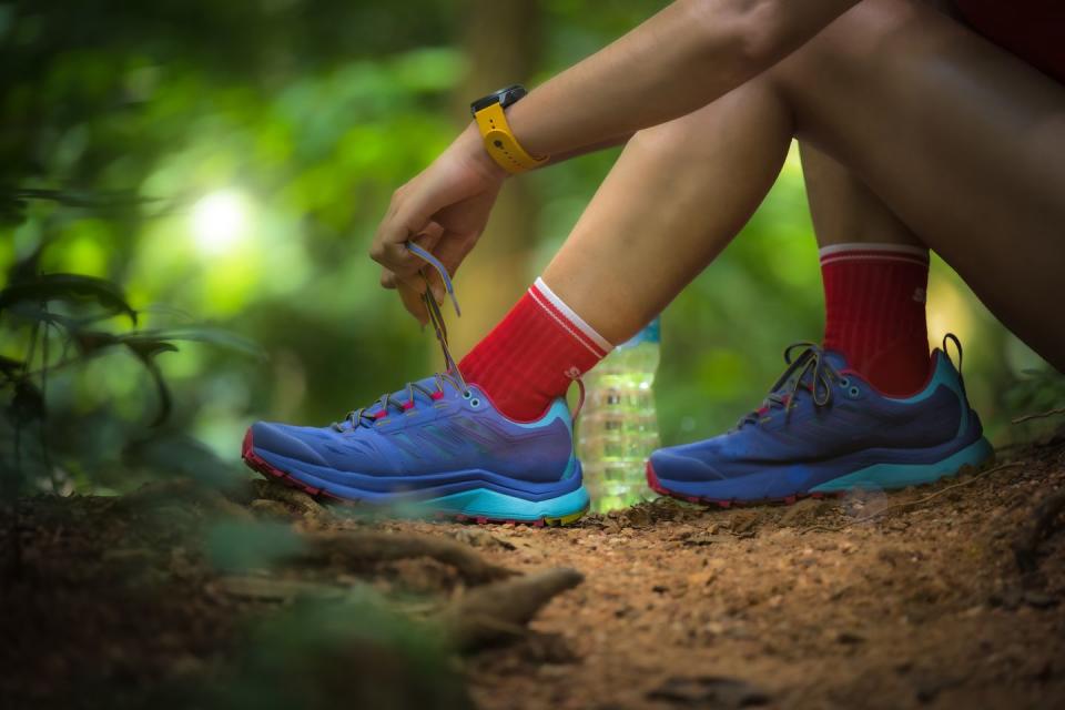 an action of the runner trail tracking try to lace of shoe securing through the way of the rest route of competition running in forest jungle