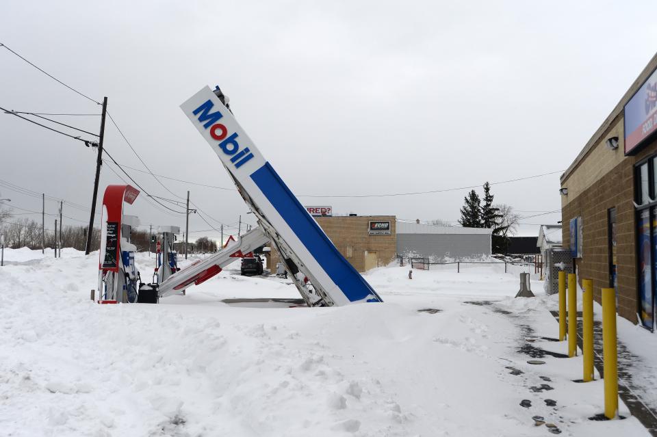 A gas station canopy lays on its side after high winds and heavy snow slammed Lackawanna, New York.