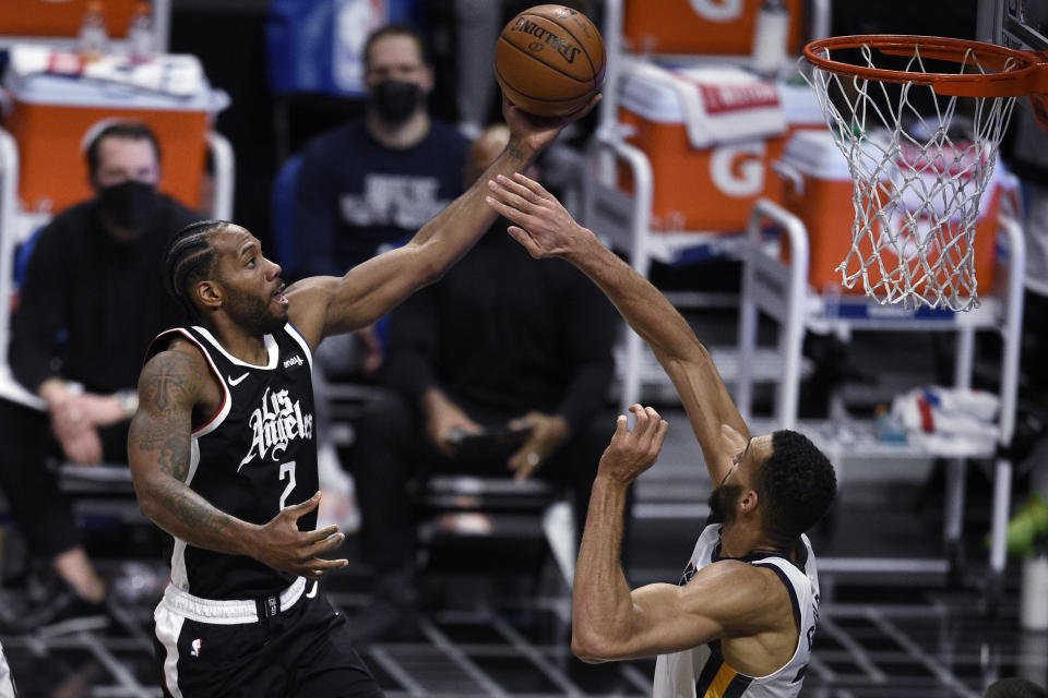 Los Angeles Clippers forward Kawhi Leonard, left, jumps up for a shot while Utah Jazz center Rudy Gobert defends during the first half of an NBA basketball game in Los Angeles, Friday, Feb. 19, 2021. (AP Photo/Kelvin Kuo)