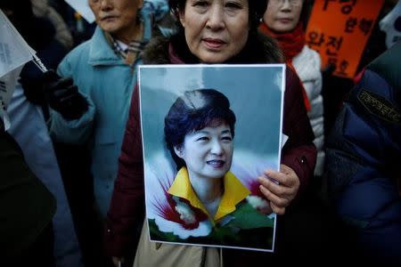 A supporter holds a portrait of South Korean President Park Geun-hye during a protest opposing her impeachment near the constitutional court in Seoul, South Korea, December 17, 2016. REUTERS/Kim Hong-Ji