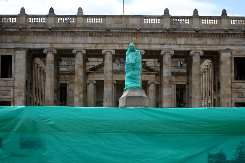 The statue of Simon Bolivar is covered with plastic, one day before a national strike in Bogota