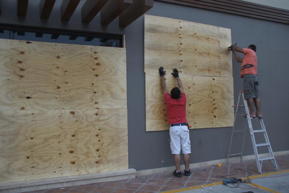 Store workers board up a wall at La Paz, Baja California as Hurricane Odile approaches September 14, 2014. Hurricane Odile sped toward Mexico's southern Baja peninsula as a dangerous storm and locals rushed to prepare ahead of a possible hit to the luxury resorts of Los Cabos later on Sunday. (REUTERS/Alejandro Acuna)