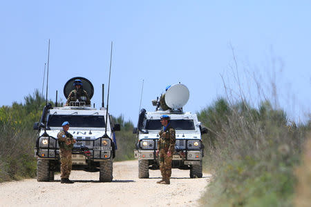 U.N. peacekeepers of the United Nations Interim Force in Lebanon (UNIFIL) stand near their vehicles during a media tour organized by Hezbollah officials, in the Lebanese village of Labbouneh near the Lebanese-Israeli border, southern Lebanon April 20, 2017. REUTERS/Ali Hashisho