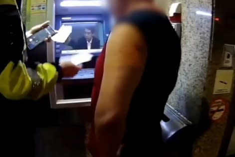 員警趕到ATM前面，阻止男子匯款。（圖／東森新聞）
