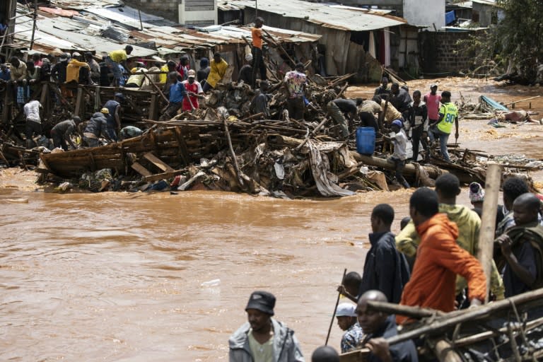 Des habitants du bidonville de Mathare près de leurs maisons détruites par les pluies diluviennes tombées sur Nairobi, au Kenya, le 24 avril 2024 (SIMON MAINA)