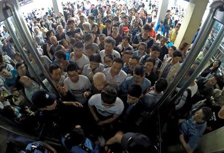 Passengers wait at a railway station to return tickets as trains are canceled due to heavy rainfall in Taiyuan, Shanxi province, China, July 20, 2016. Picture taken July 20, 2016. REUTERS/Stringer