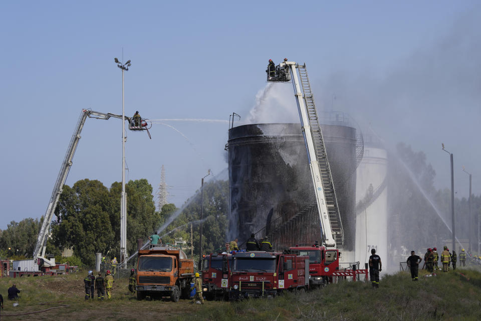 Firefighters work to extinguish a fire at an oil facility in the southern town of Zahrani, south of the port city of Sidon, Lebanon, Monday, Oct. 11, 2021. The cause of the fire was not immediately known. (AP Photo/Hassan Ammar)